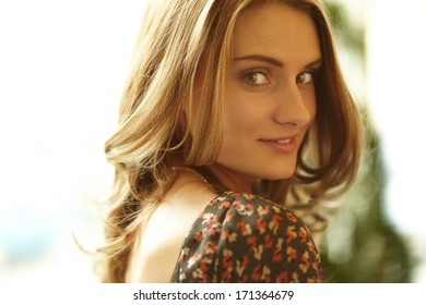 Close-up Shot Of A Gorgeous Beauty With Curly Hair And Flirty Look