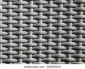 Close-up Shot Of The Grey Plastic Rattan Weaving Of A Outdoor Furniture In A Sunlight