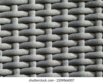 Close-up Shot Of The Grey Plastic Rattan Weaving Of A Outdoor Furniture In A Sunlight