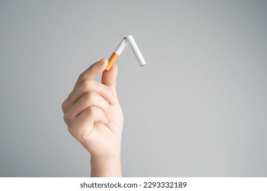 Captura de pantalla de la mano sosteniendo un cigarrillo roto. Día mundial de no fumar.