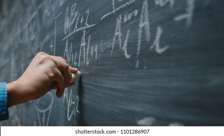 Close-up Shot Of A Hand Holding Chalk And Writing Complex And Sophisticated Mathematical Formula/ Equation On The Blackboard.