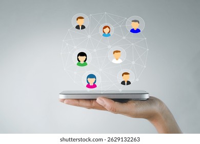 A close-up shot of a hand holding a smartphone with floating social media user icons and connected nodes, representing digital networking, online interaction, and the social media community.