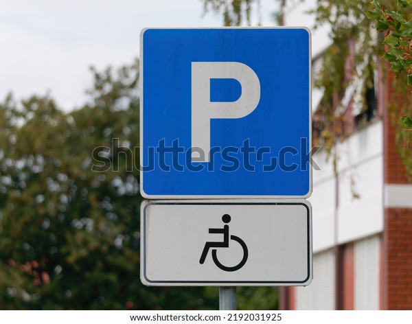 Close-up shot of a handicapped parking sign attached on\
a  metal pole 