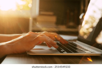 A close-up shot of hands typing on a laptop keyboard, bathed in warm sunlight. The soft glow and gentle lighting create a serene and productive atmosphere, ideal for focused work or creative tasks. - Powered by Shutterstock