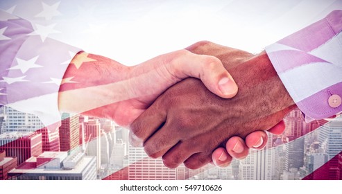 Close-up shot of a handshake in office against waving flag of america - Powered by Shutterstock