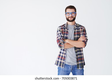 Close-up Shot Of Handsome Man In Blue Glasses Standing With Arms Folded Isolated On A White Background