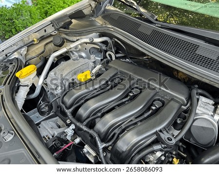 A close-up shot of a high-performance car engine, featuring a sleek black intake manifold, vibrant yellow caps, and various components showcasing advanced engineering.