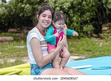 A Closeup Shot Of A Hispanic Woman Holding A Baby In The Swimming Pool In Cuba