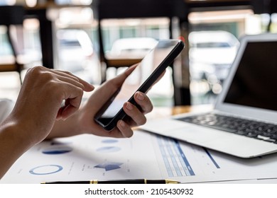 Close-up shot of holding a cell phone and using it, she is looking at information on a mobile phone that the financial officer sends through an online messaging program. Financial concepts. - Powered by Shutterstock