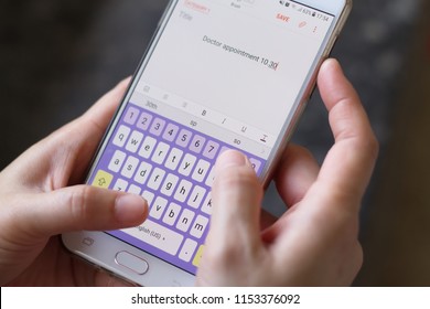 Close-up Shot Of Human Hands Holding Mobile Phone, And Making A Reminder Of Doctor Appointment Date And Time.