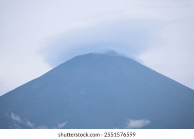 A close-up shot of Japan’s iconic Mount Fuji, its summit beautifully enveloped by a rare lenticular cloud. - Powered by Shutterstock