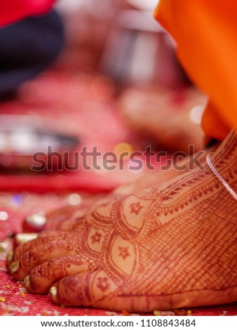 The close-up shot of Indian Maharashtrian bride with beautiful mehndi (henna) on feets