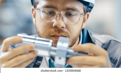 Close-up Shot of the Industrial Engineer Wearing Classes and Hard Hat Connects Two Components He Designed. Precision in Mechanical Engineering.