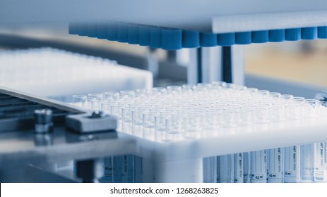 Close-up Shot of the Industrial Manufacturing Medical Test Tubes, Closing Caps put on Tubes. Sterile High Precision Factory Machinery Producing Items for Medical Use. Abstract Industrial Concept.