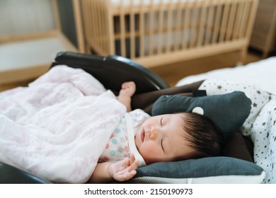 Closeup Shot Innocent Baby Sleeping Peacefully In Bouncer Chair. Daytime Female Newborn Napping Alone With Blurred Background. 