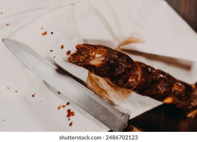 A close-up shot of a knife and a sausage on a white napkin - Powered by Shutterstock