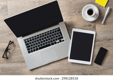Closeup shot of laptop with digitaltablet and smartphone on desk. Modern devices on desk at office. Three different type of screen to put your responsive web page on.