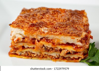 A closeup shot of lasagna on a white plate - Powered by Shutterstock