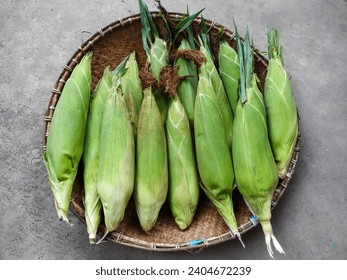 Closeup Shot of Maize or Sweet Corn Pile (Zea Mays) on A Woven Bamboo Tray in the Cement Texture Background