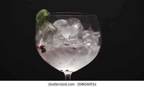 Close-up Shot Of Making Fizzy Gin And Tonic Cocktail With Ice. Refreshing Drink Against Black Background