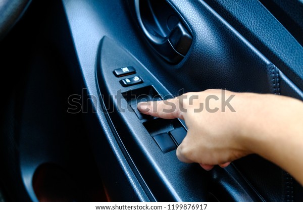 Closeup shot of male\
driver pressing button locking doors in car, Finger push lock\
button of car doors, The hand of a woman is pressing the lock door\
button from the\
interior.