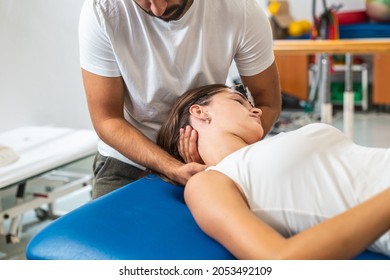 Close-up shot of a male physiotherapist doing manual neck stretching to a young Caucasian female patient. - Powered by Shutterstock