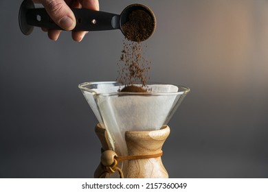 closeup shot of man adding coffee in pour over glass - Shutterstock ID 2157360049