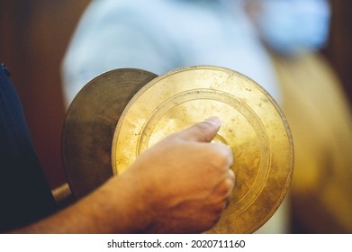 A Closeup Shot Of A Man Playing Hand Cymbals On A Blurred Background