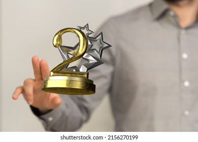 A Closeup Shot Of A Man Showing The 2nd Place Trophy