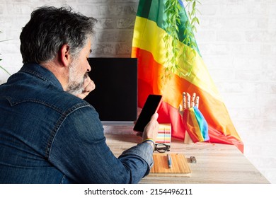 A Close-up Shot Of A Man Working In An Office With LGBT Accessories