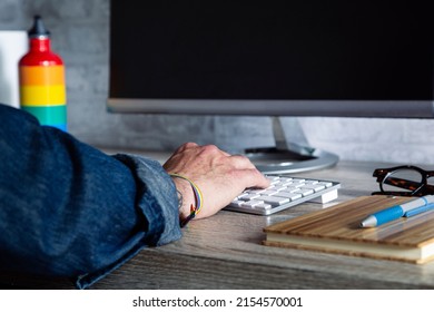 A Close-up Shot Of A Man Working In An Office With LGBT Accessories