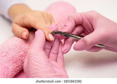 Close-up Shot Of A Manicurist Using A Cuticle Clipper To Give A Nail Manicure To Her Client In The Beauty Salon. Master Of Manicure Remove A Cuticle Nail With Nail Clipper.