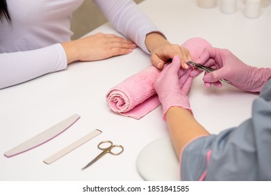 Close-up Shot Of A Manicurist Using A Cuticle Clipper To Give A Nail Manicure To Her Client In The Beauty Salon. Master Of Manicure Remove A Cuticle Nail With Nail Clipper.