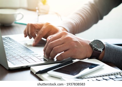 Close-up shot of man's hand with watch on his wrist. using keyboard of laptop computer on office desk. businessman working in office. Business investment-finance accounting concept. - Powered by Shutterstock