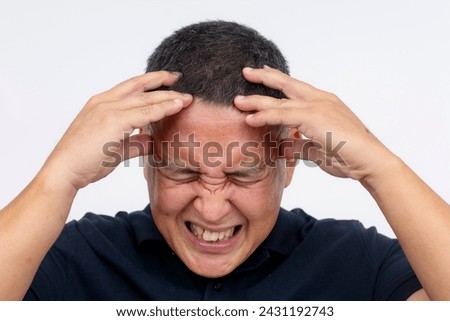 Closeup shot of a middle-aged man isolated on white, clutching his head and wincing in pain, depicting a severe headache or migraine.
