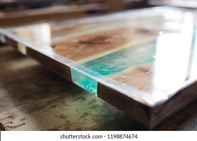 Closeup shot of modern wooden table top with epoxy resin element covered with lacquer 