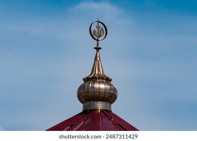 A close-up shot of a mosque dome with an intricate design, set against a clear blue sky. - Powered by Shutterstock
