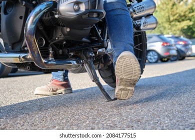Close-up shot of motorcyclist positioning the kickstand
