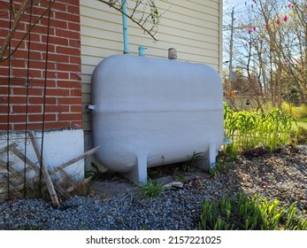 A Closeup Shot Of An Oil Tank Against A House.