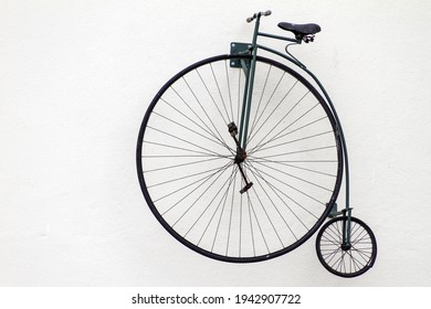 A closeup shot of an old bicycle with a big wheel on a white background