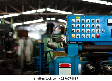 Close-up shot of an old blue machine controller in a heavy industrial factory. 