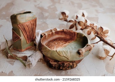 A Closeup Shot Of Old Ceramic Cooking Pot With Dried Cotton Plant N A Table