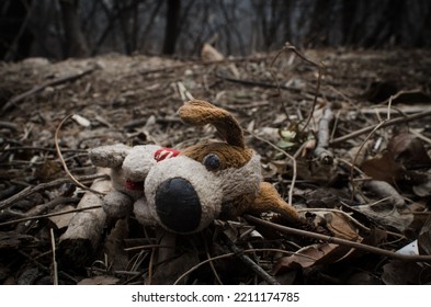 A Closeup Shot Of An Old Dirty Dog Toy Neglected On The Ground In The Forest - Missing Child Concept