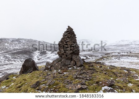 A closeup shot of an old stone cairn in winter landscape in Iceland