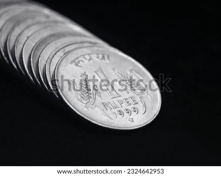 closeup shot of old vintage silver one or 1 rupee coin of india arranged in a straight row isolated in a black background