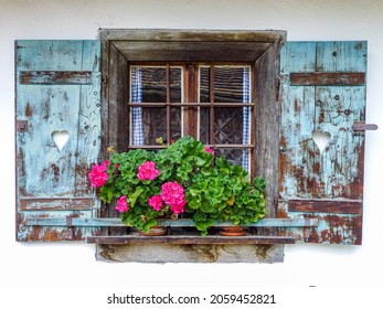 A Closeup Shot Of An Old Wooden Window With Flowers On The Sill