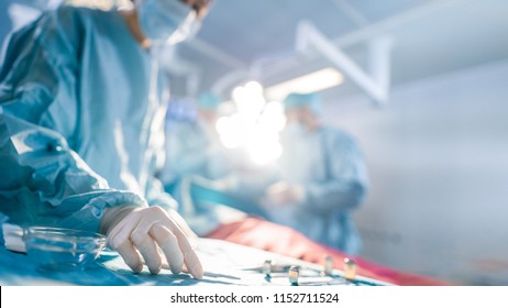 Close-up Shot in Operating Room of Surgical Table with Instruments, Assistant Picks up Instruments for Surgeons During Operation. Surgery in Progress. Professional Medical Doctors Performing Surgery. - Shutterstock ID 1152711524