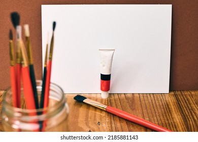 Closeup Shot Of Painter's Tools, Brushes, Empty Canvas And Oil Paint Tubes