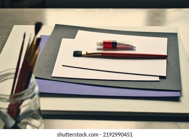 Closeup Shot Of Painter's Tools, Empty Blank Canvas, Brushes And Tube Of Oil Paint 