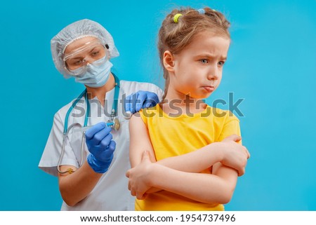 Close-up shot of pediatrician giving a little girl intramuscular injection in arm. The concept of vaccination of children and the prevention of infectious diseases. Vaccination of the child.